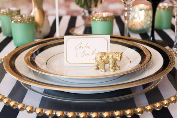 decor de table mariage chic et raffinée aux couleurs noires blanches et dorés, avec accessoires comme animaux en miniatures dores